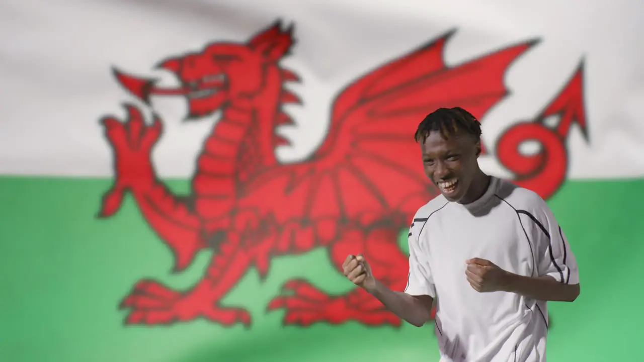 Young Footballer Celebrating to Camera In Front of Wales Flag 02