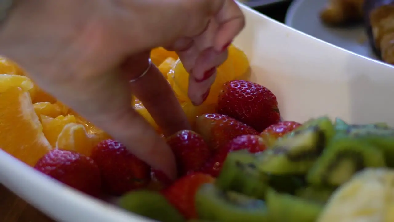 Close up shot of women picking up strawberries