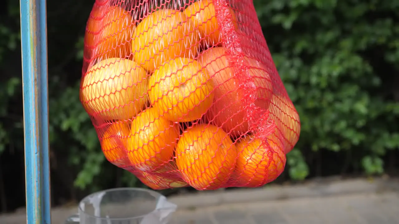 Fresh Orange Fruits in a red basket Oranges on a blurred greenery background