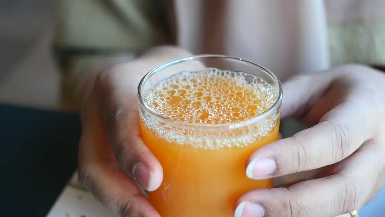 Women holding a glass of orange juice