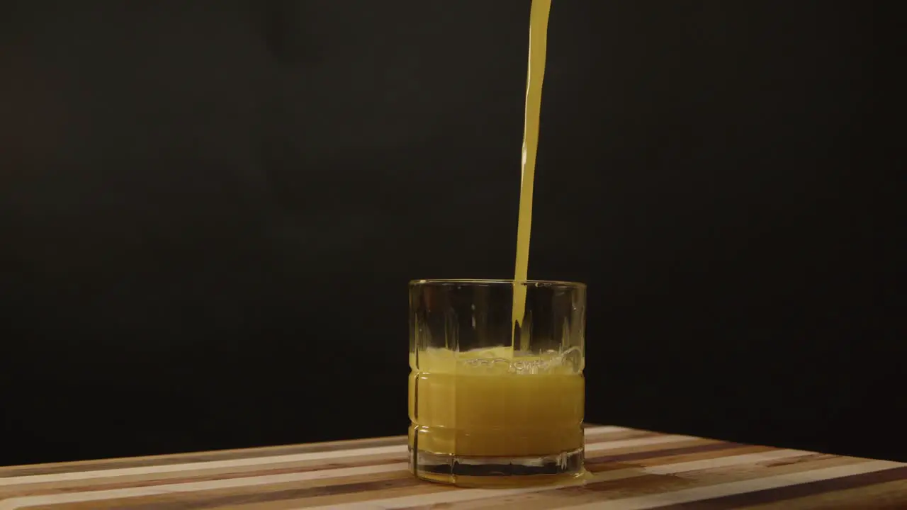 Orange juice is poured into a short spinning