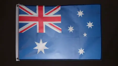 Studio Shot Of Flag Of Australia Flying Against Black Background