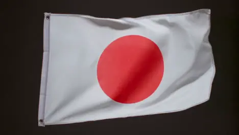 Studio Shot Of Flag Of Japan Flying Against Black Background 1