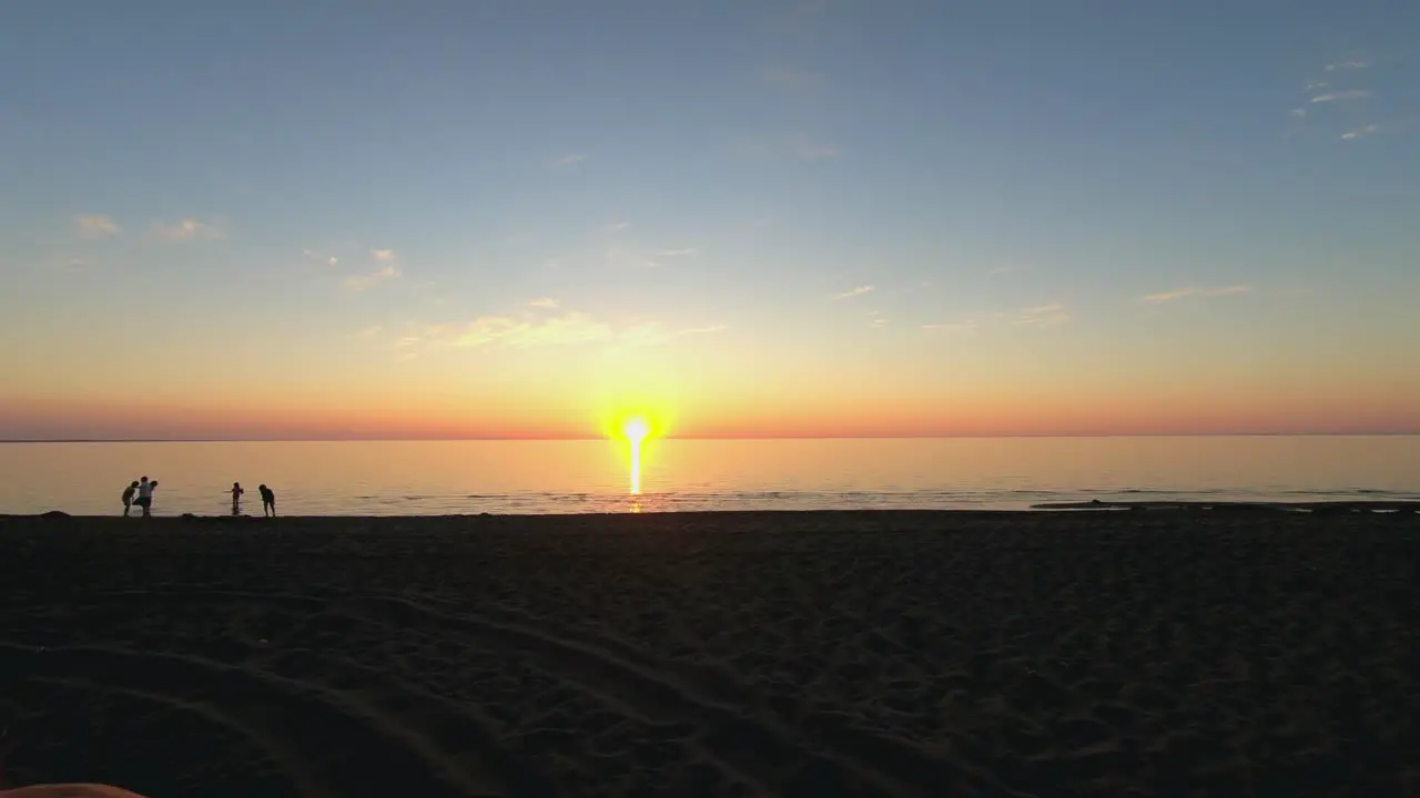 Timelapse of a sunny beach with people playing and working in the water