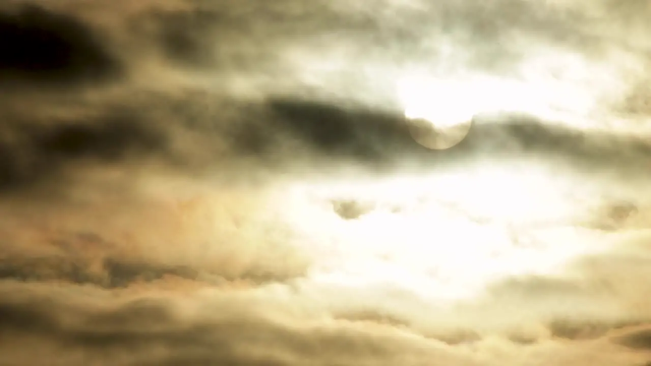 Full Moon or Sun moving behind beautiful clouds in dark black sky