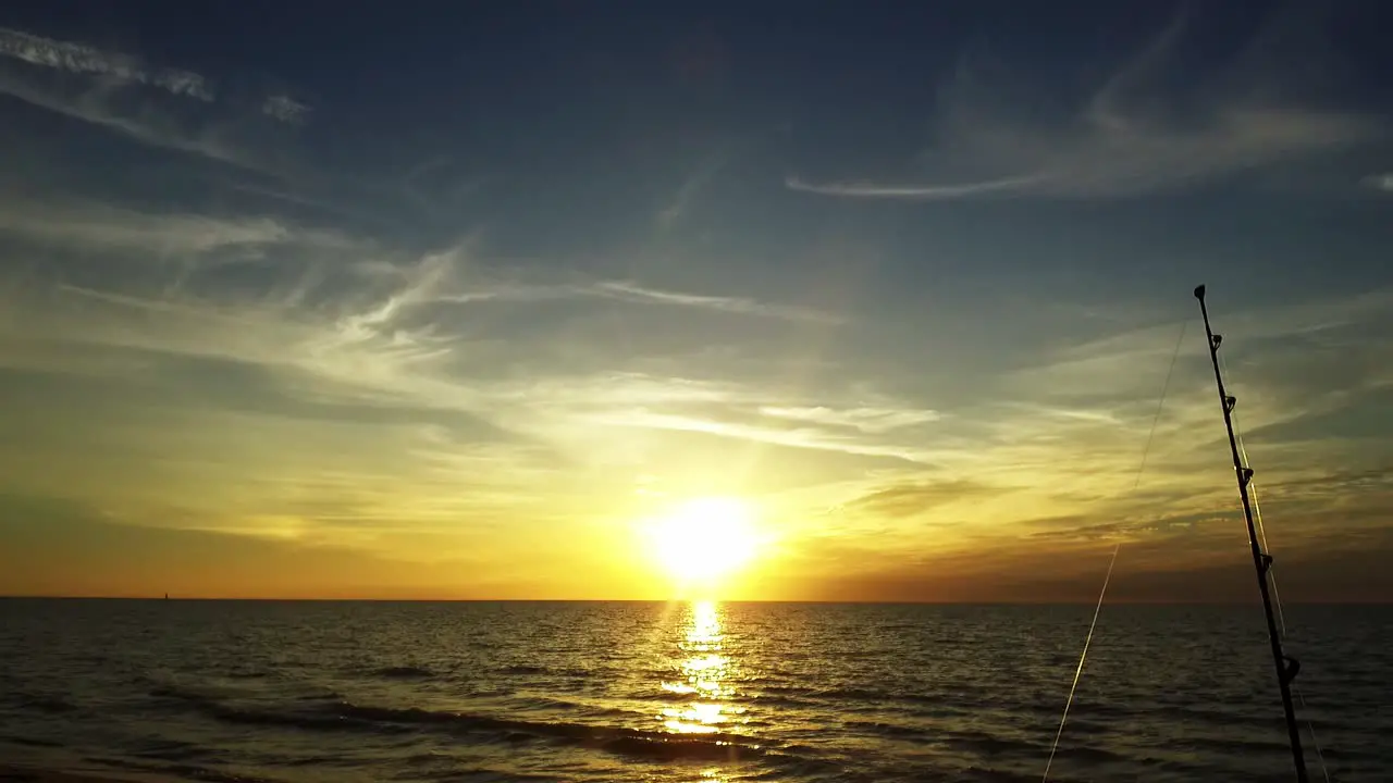 A fishing line glistens in the glden sunset in front of the gulf