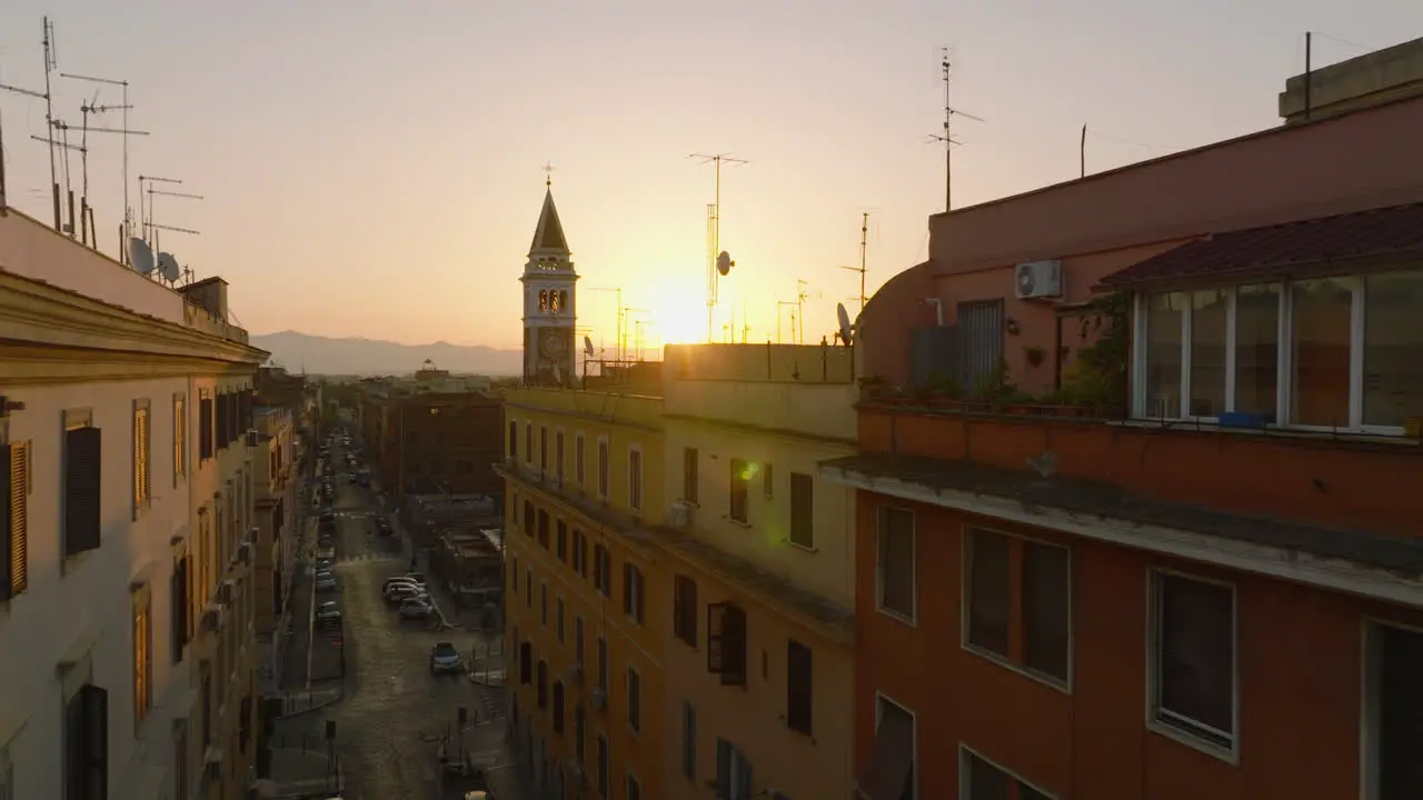 Aerial ascending footage of apartment houses and tower in city centre View against rising sun Rome Italy