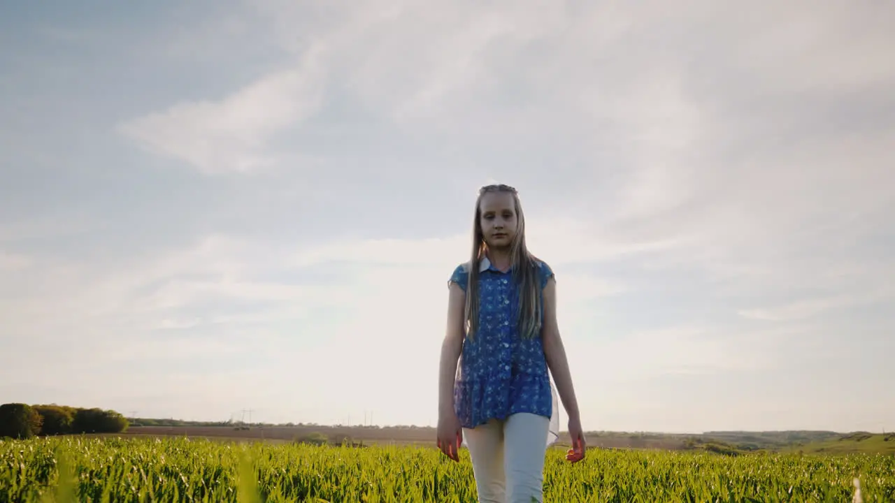 Thoughtful Girl Walks Through A Green Meadow