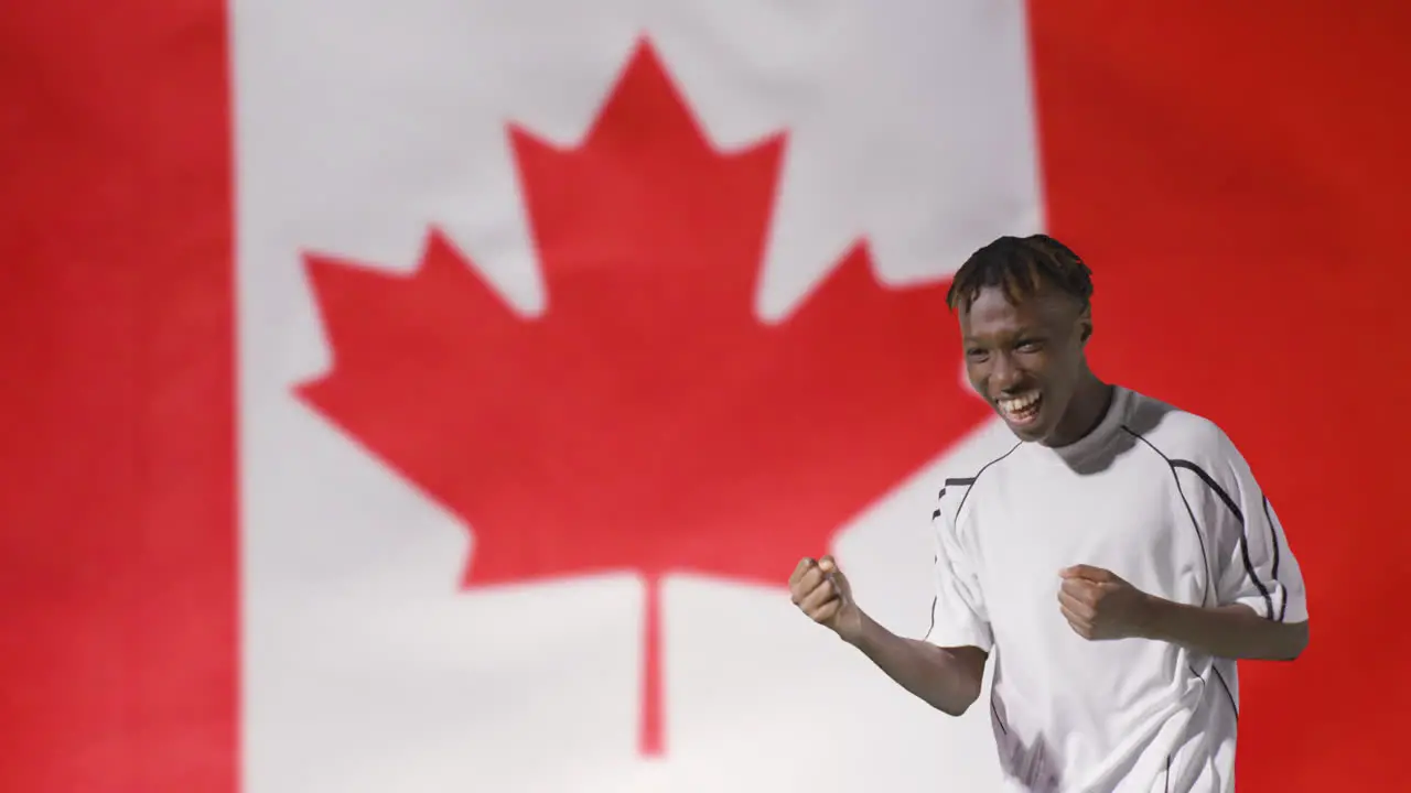 Young Footballer Celebrating to Camera In Front of Canada Flag 02