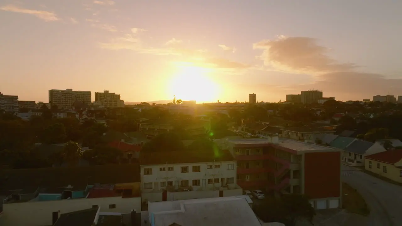 Low flight above buildings in city Aerial panoramic romantic footage against setting sun Port Elisabeth South Africa