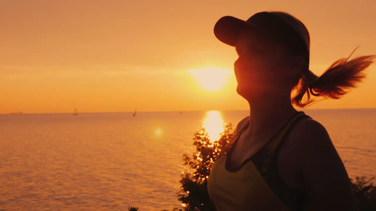 Healthy Young Woman Jogging In The Background Of The Sea And The Setting Sun