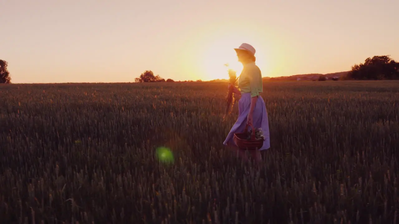 A Happy Carefree Woman With A Basket Of Wildflowers Walks At Sunset In A Picturesque Place 4K Video