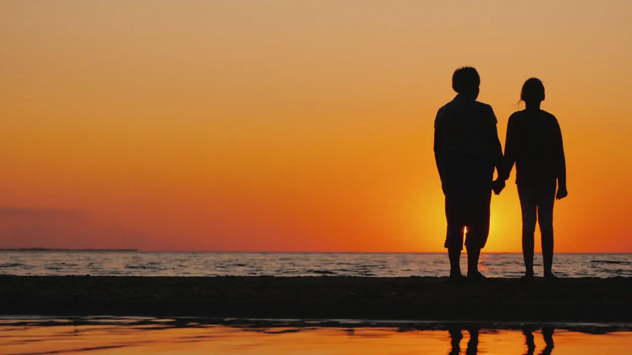 An Elderly Woman Stands Next To Her Granddaughter At Sunset Active Seniors