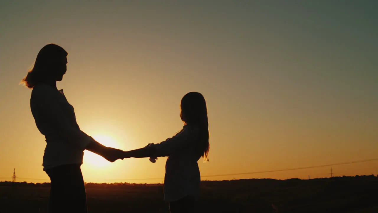 Mom Holds Her Daughter's Hands Stand Alone At Sunset Single Parent Concept 4K Video