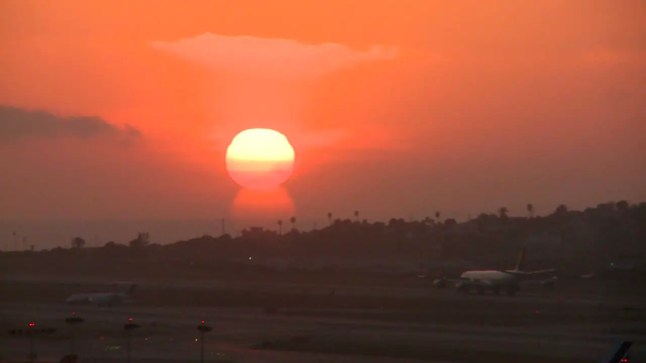 A plane arrives at an airport at sunset or sunrise