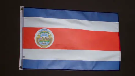 Studio Shot Of Flag Of Costa Rica Flying Against Black Background