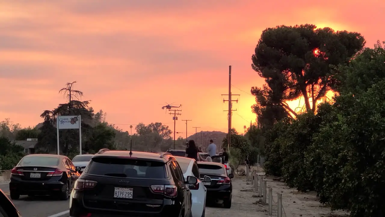 Bright orange and red sunset in California wild fire smoke people watching