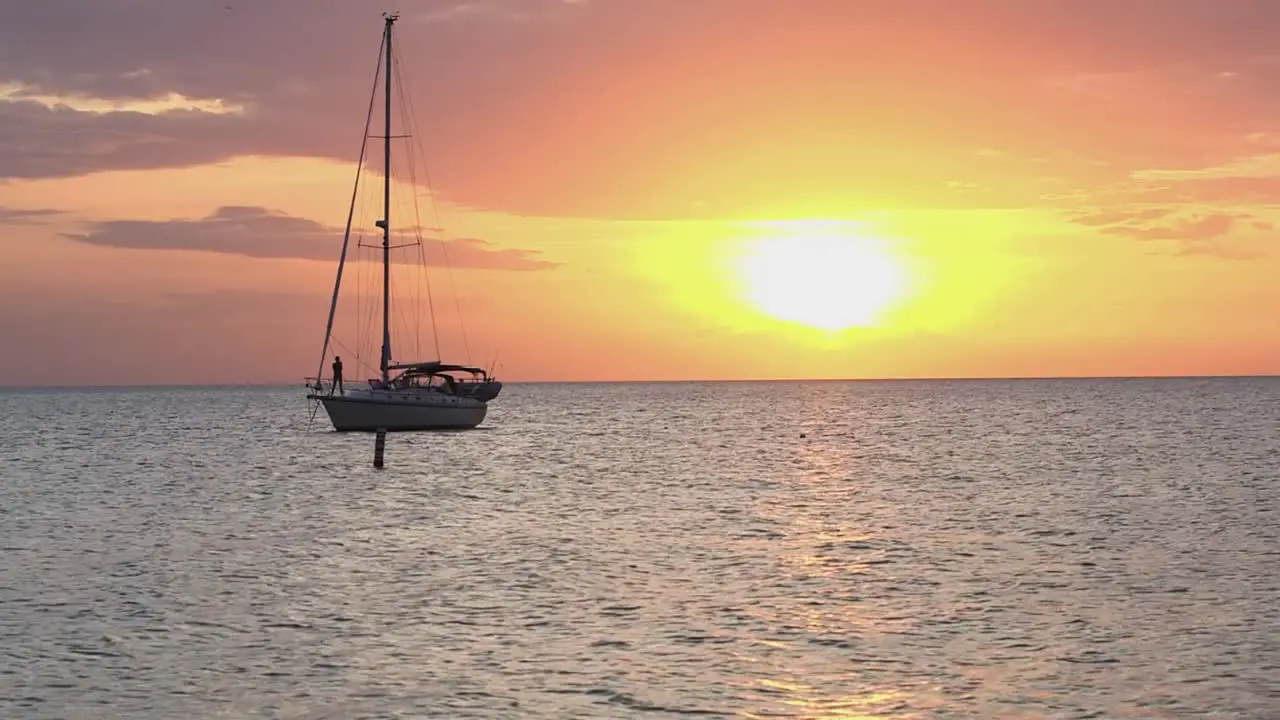 Sailboat anchored on Florida Coast with gorgeous creamsicle sunset