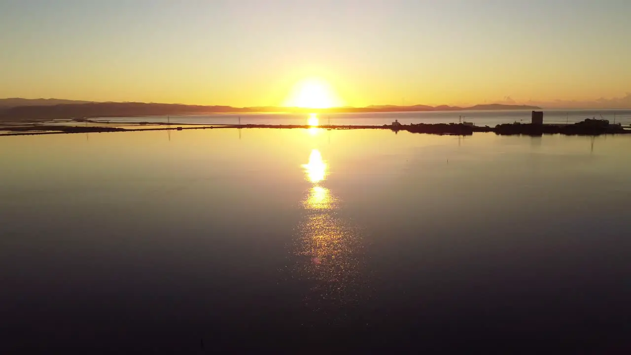 Peaceful scenery of sun rising above hills in Sant'Antioco aerial drone static