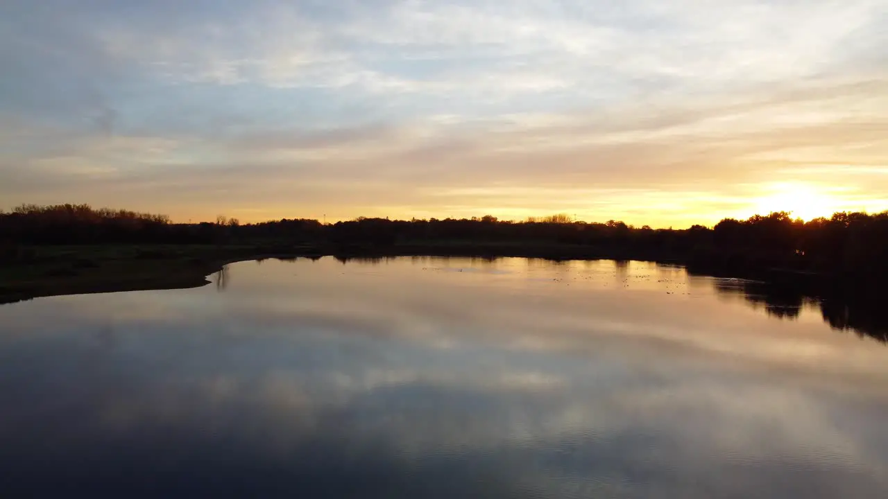 Relaxing landscape with lake water and golden sunset in Belgium aerial drone view