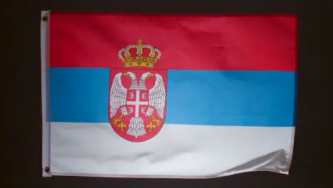 Studio Shot Of Flag Of Serbia Flying Against Black Background