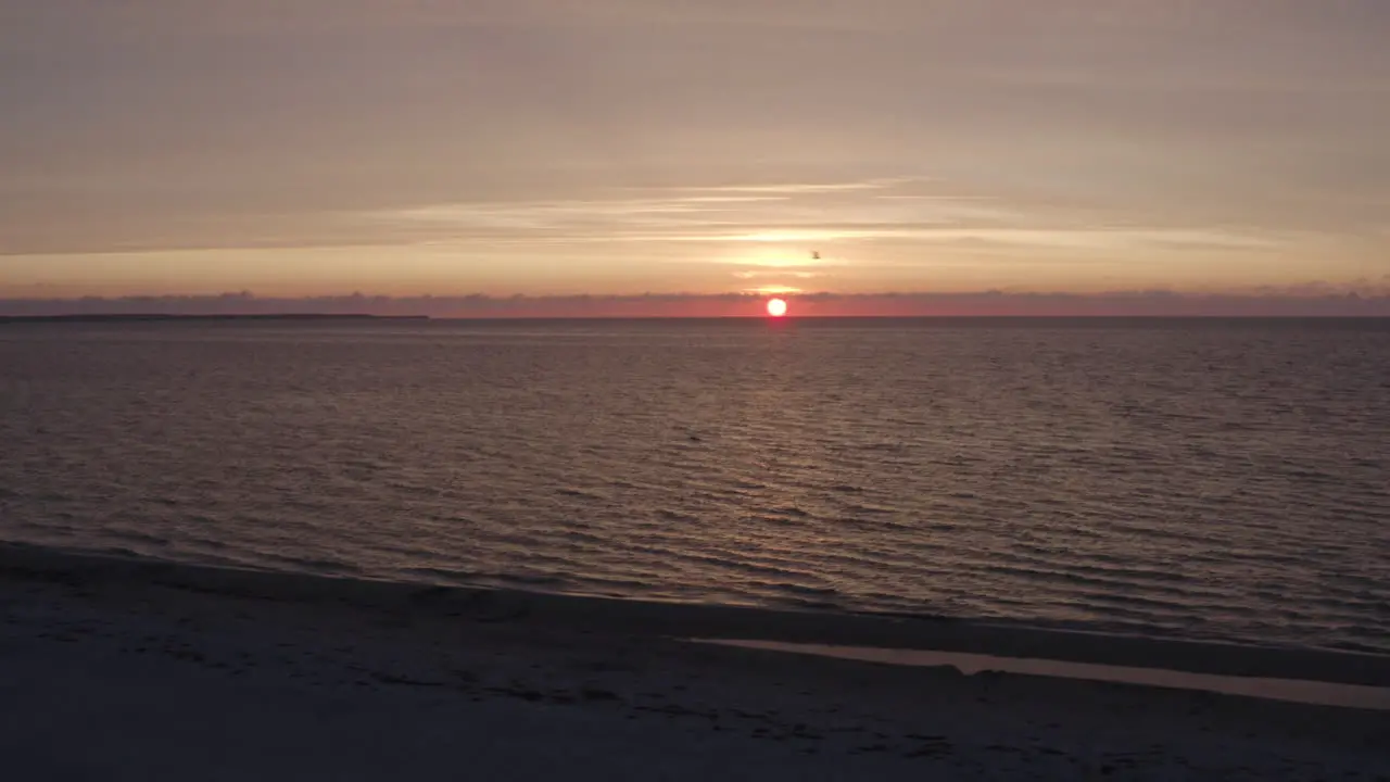 4k Aerial moving shot of a beautiful sunset in the ocean water in the horizon