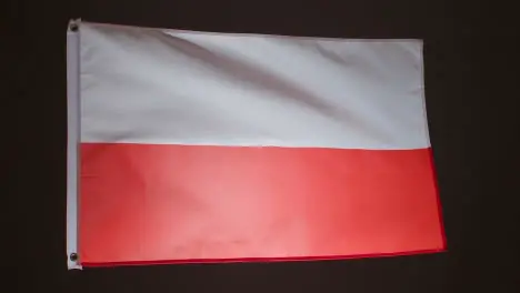 Studio Shot Of Flag Of Poland Against Black Background