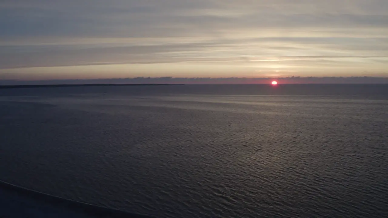 4k Aerial shot of a golden sunset over ocean water