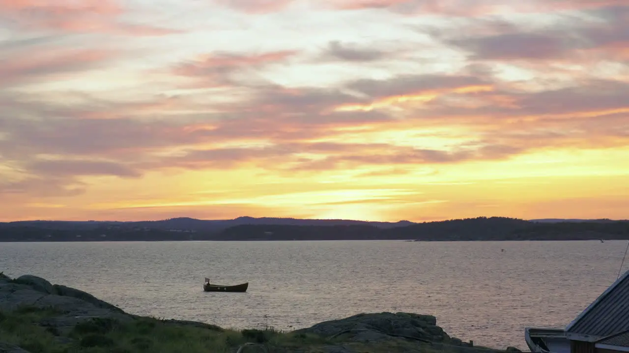 Birds Flying Over The Small Boat Near Store Torungen Island During Golden Sunset In Arendal Town Norway