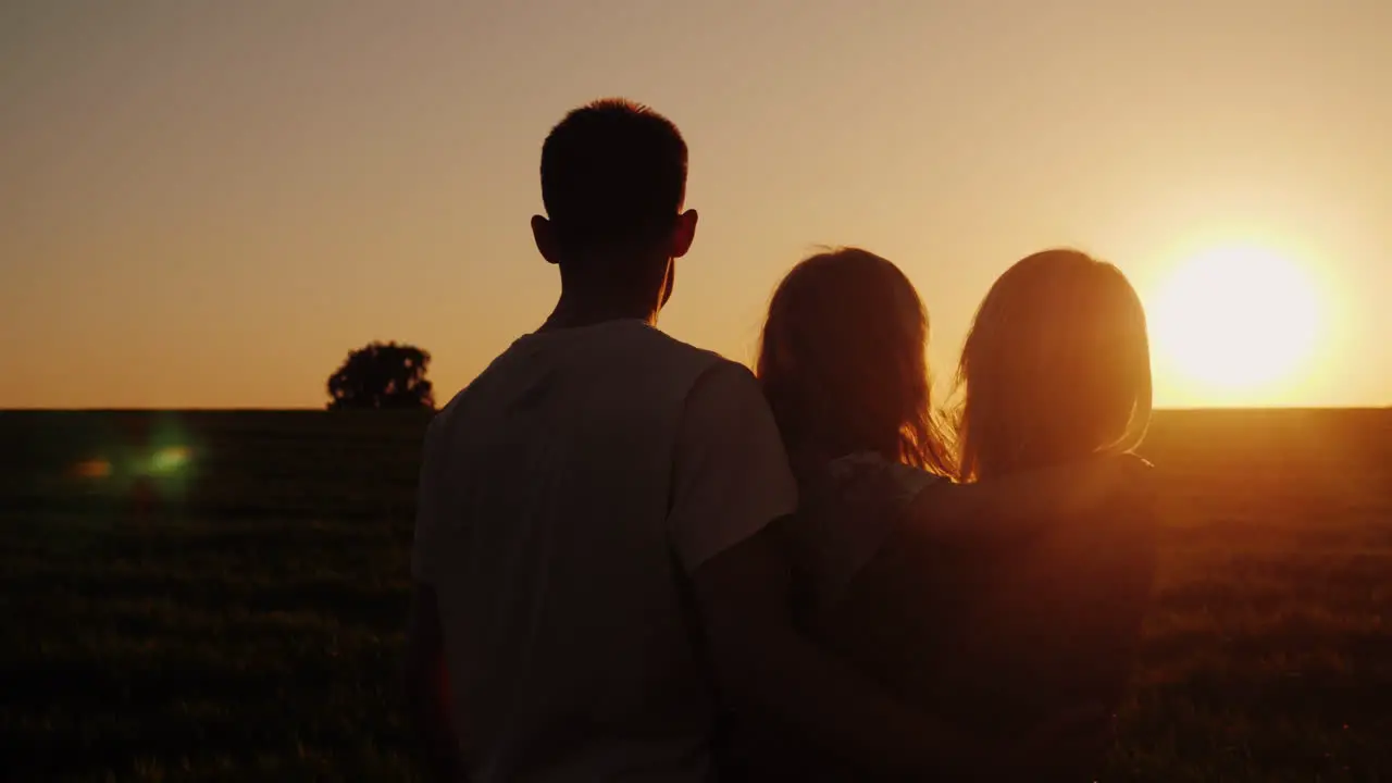 A Family Of Three Looks Forward To A Beautiful Sunset Back View 4K Video