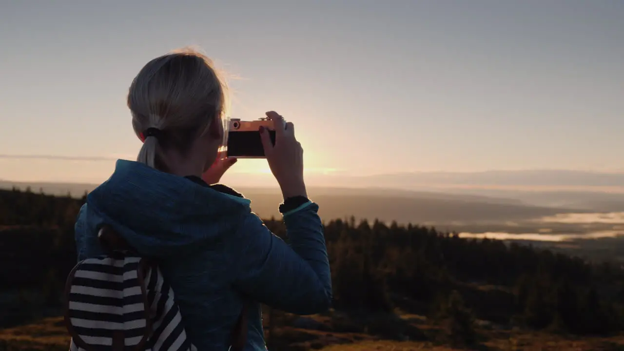 An Active Woman Is Taking Pictures Of A Beautiful Landscape With A Retro Camera Standing On The Top 