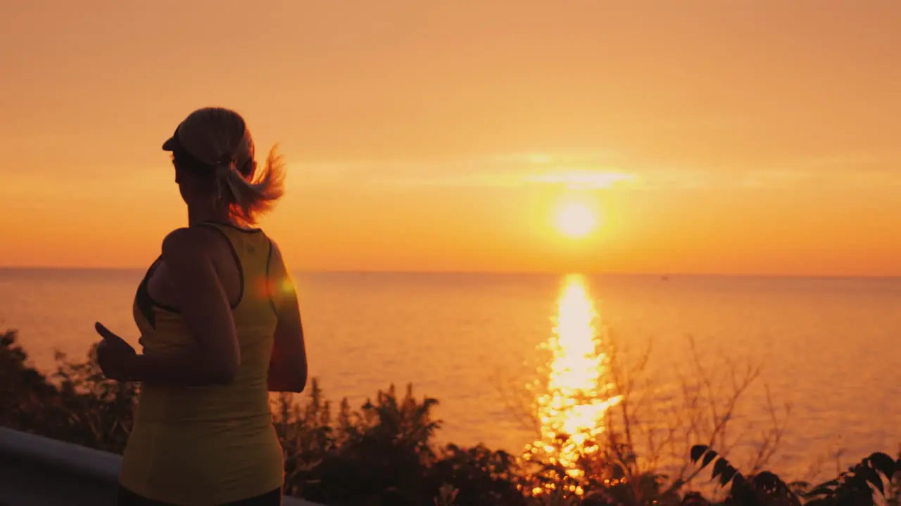 Active And Healthy Lifestyle Woman Silhouette Running Along The Road Along The Sea At Sunset