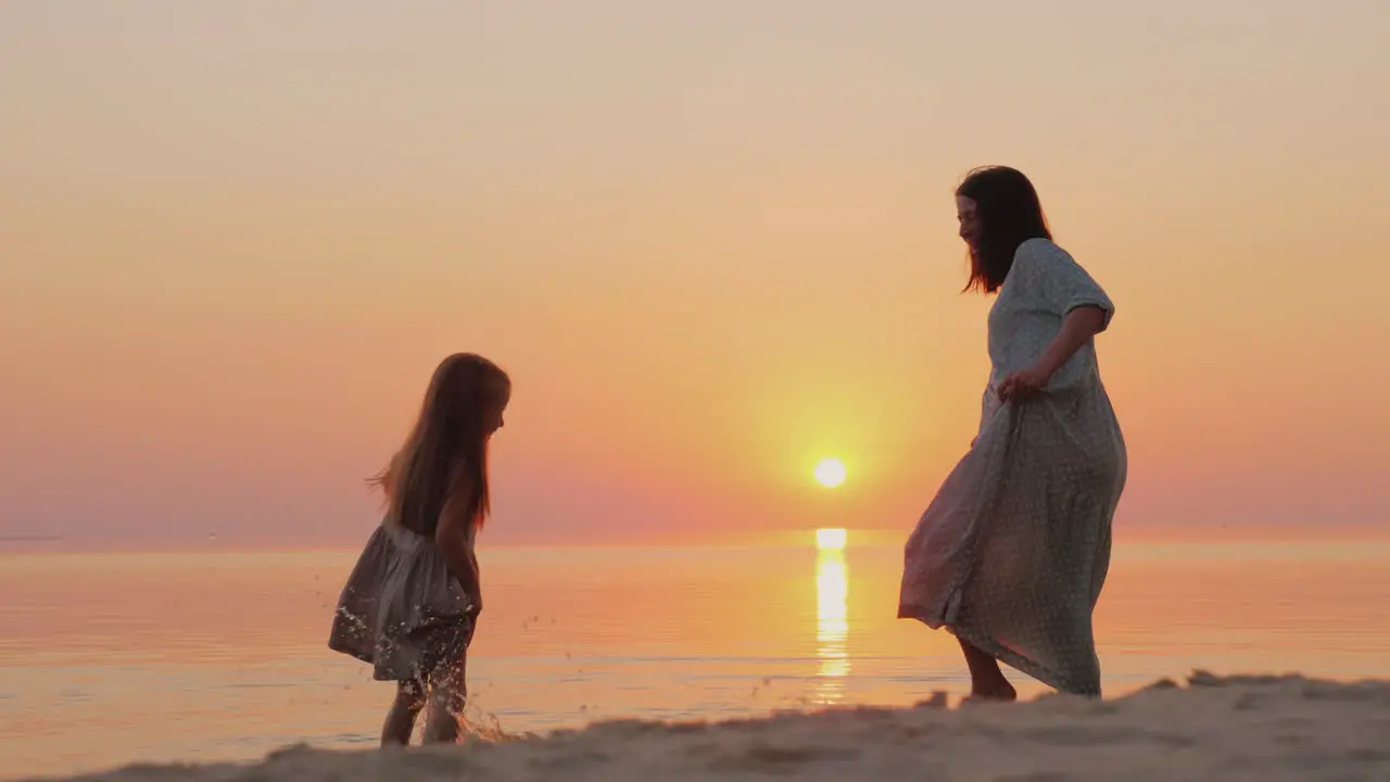 A Pregnant Mother Plays With Her Daughter For Six Years By The Water Happy And Have Fun Togetherr Wa