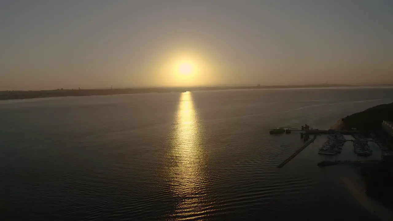 Dramatic sunset with orange sky in a sunny day over river with setubal in background