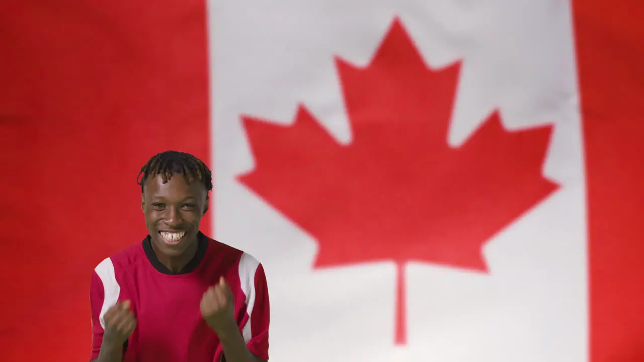 Young Footballer Celebrating to Camera In Front of Canada Flag 01