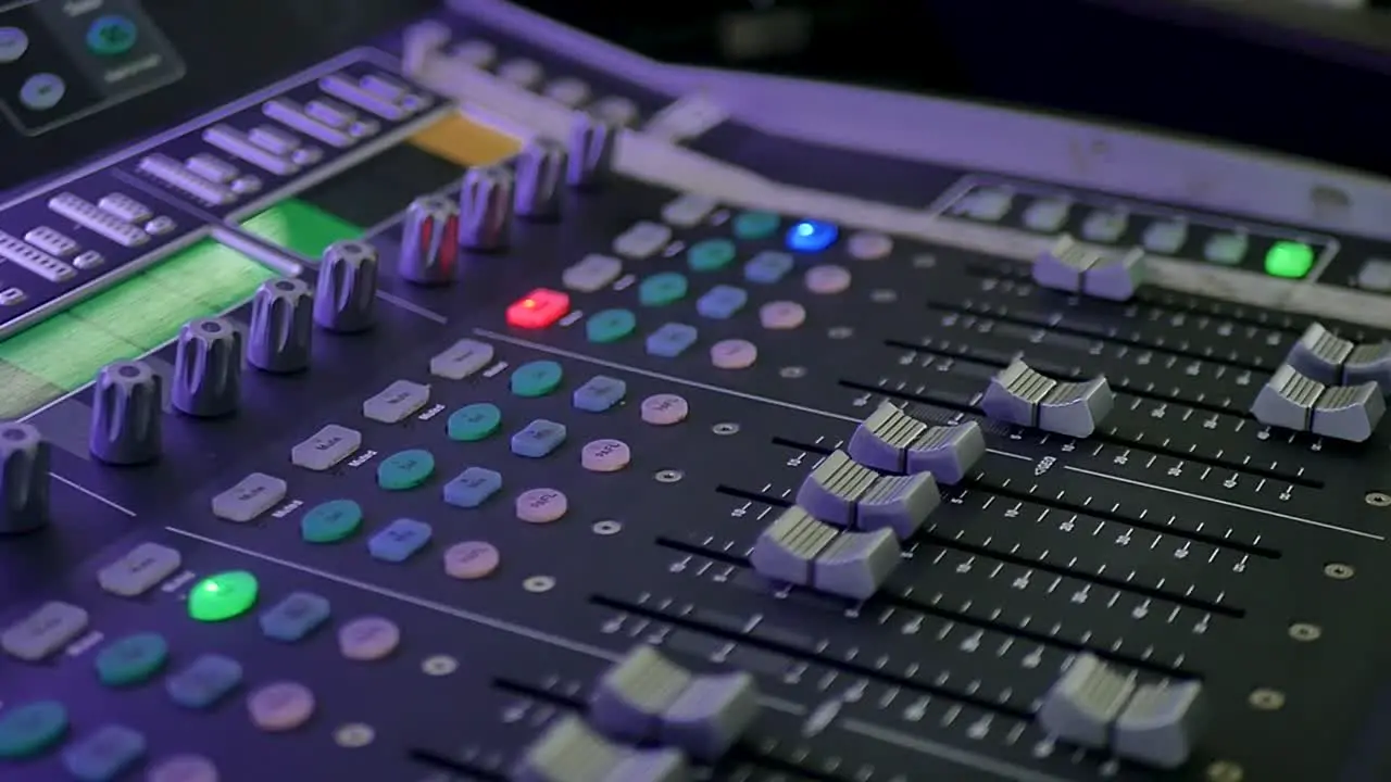 A detailed close-up shot of audio mixer buttons being manipulated by a professional