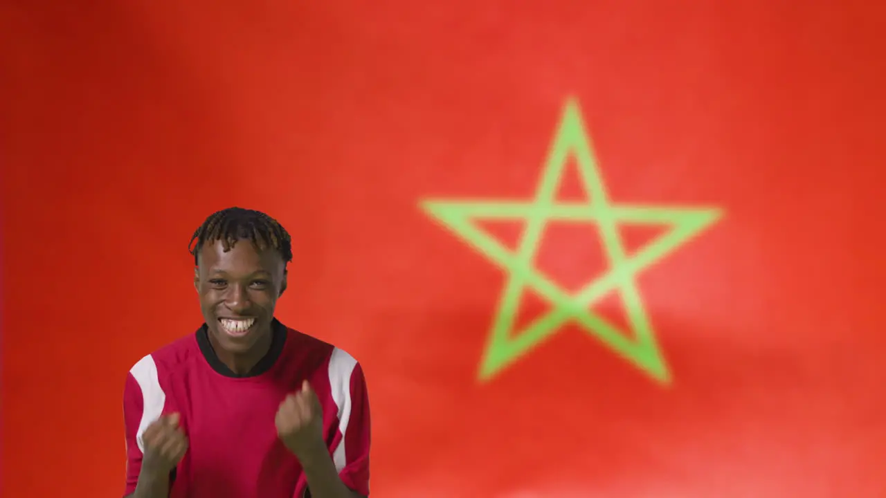 Young Footballer Celebrating to Camera In Front of Morocco Flag 01