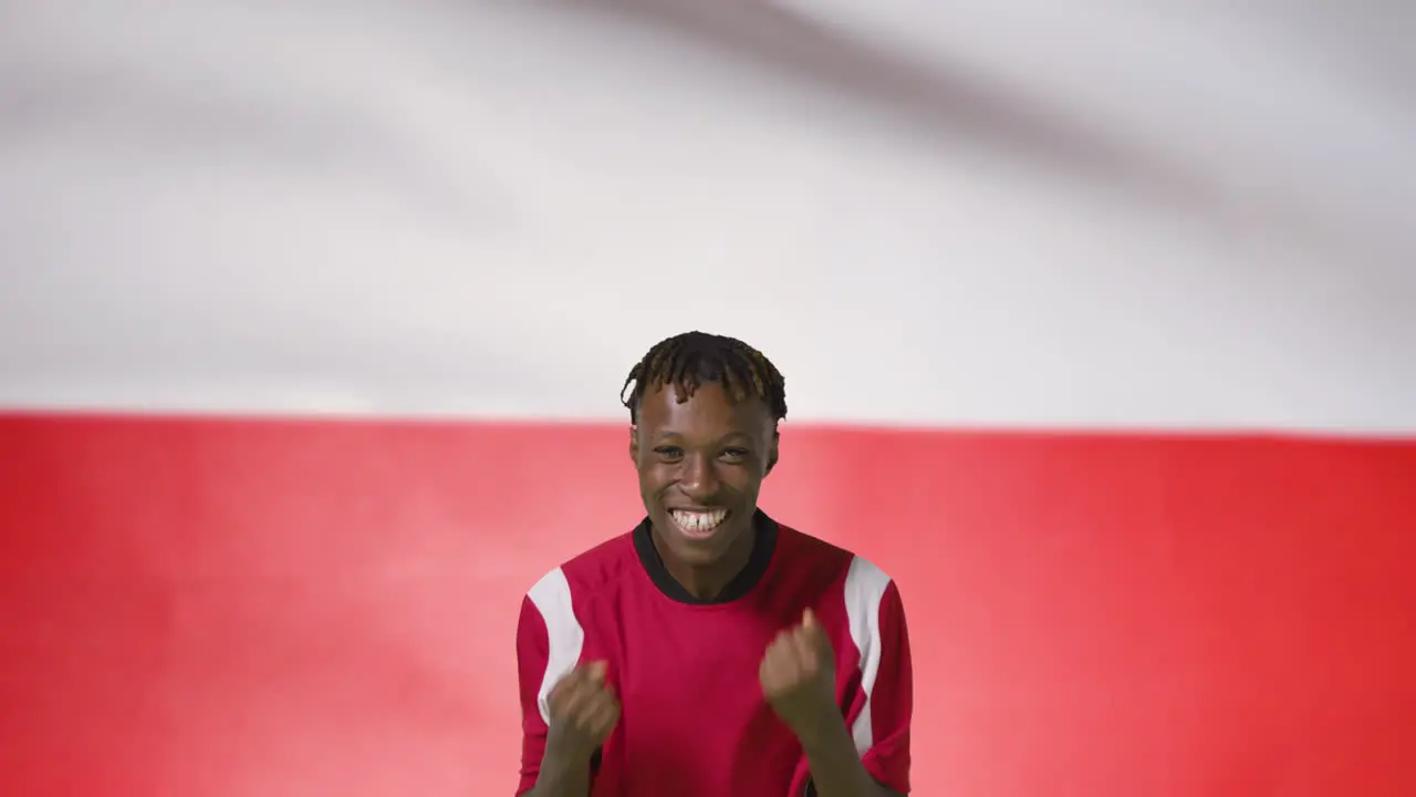 Young Footballer Celebrating to Camera In Front of Poland Flag 01