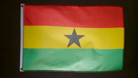 Studio Shot Of Flag Of Ghana Flying Against Black Background