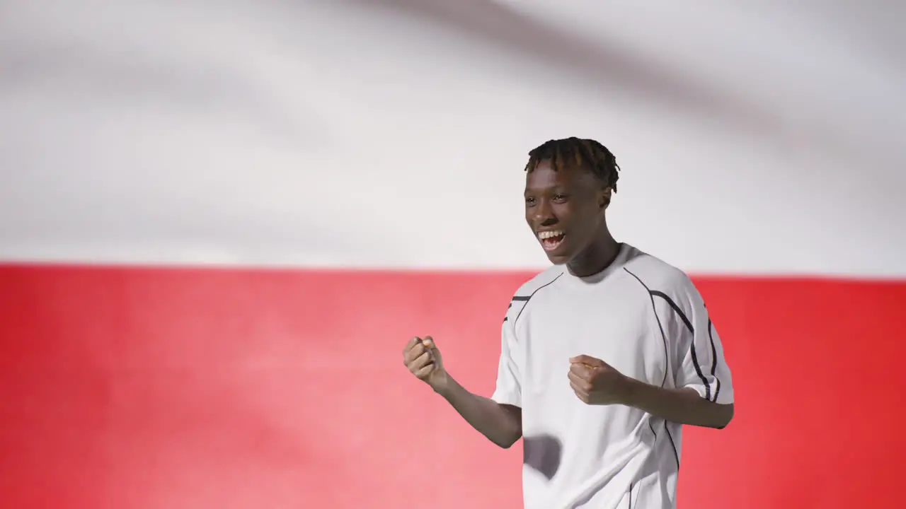 Young Footballer Celebrating to Camera In Front of Poland Flag 02