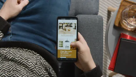 Overhead Shot Of Person At Home Shopping Online Looking At Target Website On Mobile Phone 1