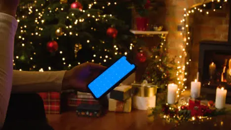 Christmas At Home With Person Looking At Blue Screen Mobile Phone 3