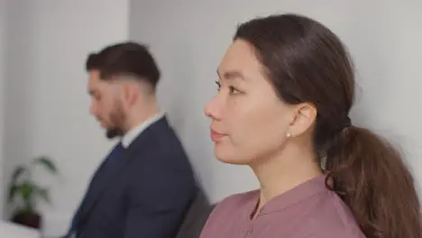 Male And Female Candidates In Office Waiting For Job Interview Looking At Mobile Phone And Reading Notes 4