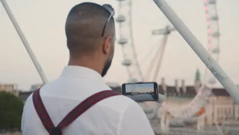 Man Recording Video On Mobile Phone Using Gimbal Of London Eye England UK