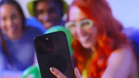 Studio Shot Of Group Of Gen Z Friends Sitting On Sofa Posing For Selfie With Toy Alien On Mobile Phone 5