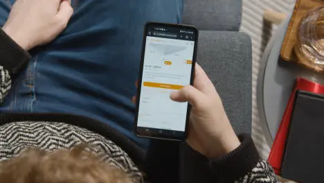 Overhead Shot Of Person At Home Shopping Online Looking At Alibaba Website On Mobile Phone 1