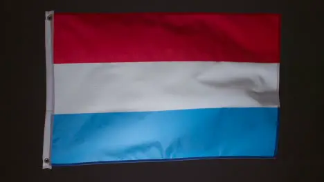 Studio Shot Of Flag Of Netherlands Flying Against Black Background