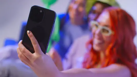 Studio Shot Of Group Of Gen Z Friends Sitting On Sofa Posing For Selfie With Toy Alien On Mobile Phone 3