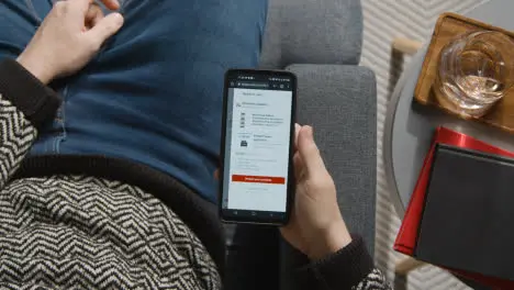 Overhead Shot Of Person At Home Shopping Online Looking At Target Website On Mobile Phone 2