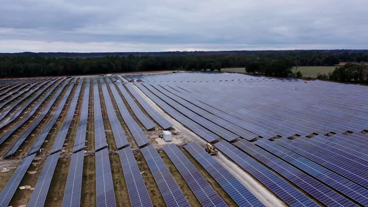 fly drone over solar panel field on cloudy day